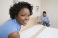 Couple Arranging Bed At Home Royalty Free Stock Photo