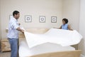 Couple Arranging Bedsheet