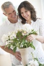 Couple Arranging Flowers In Vase