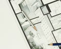 Couple of artistic drawing pencils on authentic real estate floor plan graphic material