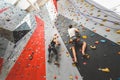 Couple of athletes climber moving up on steep rock, climbing on artificial wall indoors. Extreme sports and bouldering Royalty Free Stock Photo