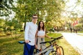 Couple of attractive, youthful, and cheerful bicyclist is posing for the camera with their bikes, feeling relaxed, standing in the Royalty Free Stock Photo