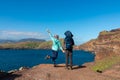 Sao Lourenco - Couple with baby carrier looking at majestic Atlantic Ocean coastline at Ponta de Sao Lourenco peninsula, Canical