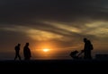 Couple with a baby walking in sunset on the beach