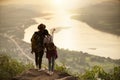 Couple backpacker standing on cliff with sunset