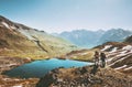 Couple backpackers hiking in mountains over lake