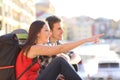 Couple of backpackers pointing landmark in the street Royalty Free Stock Photo