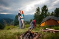 Couple backpackers standing near the campfire, tent, backpacks Royalty Free Stock Photo