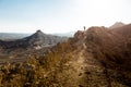 Couple backpackers walking ascending mountain ridge desert trai Royalty Free Stock Photo