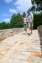 Couple of backpackers walking on bridge Royalty Free Stock Photo
