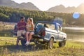 Couple With Backpacks In Pick Up Truck On Road Trip By Lake Drinking Beer Royalty Free Stock Photo