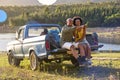 Couple With Backpacks In Pick Up Truck On Road Trip By Lake Drinking Beer Royalty Free Stock Photo