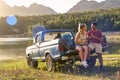 Couple With Backpacks In Pick Up Truck On Road Trip By Lake Drinking Beer Royalty Free Stock Photo