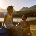 Couple With Backpacks In Pick Up Truck On Road Trip By Lake At Sunset Royalty Free Stock Photo