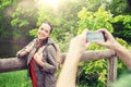 Couple with backpacks taking picture by smartphone Royalty Free Stock Photo