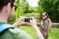 Couple with backpacks taking picture by smartphone Royalty Free Stock Photo