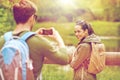 Couple with backpacks taking picture by smartphone Royalty Free Stock Photo