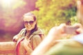 Couple with backpacks taking picture by smartphone Royalty Free Stock Photo