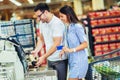 Couple with bank card buying food at grocery store or supermarket self-checkout