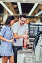 Couple with bank card buying food at grocery store or supermarket self-checkout