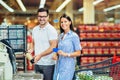 Couple with bank card buying food at grocery store or supermarket self-checkout