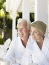 Couple In Bathrobes With Cups On Verandah Royalty Free Stock Photo
