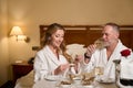 Couple in bathrobes enjoys oysters and champagne in luxury hotel room Royalty Free Stock Photo