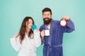 Couple in bathrobes with mugs. Man with beard and sleepy woman enjoy morning coffee or tea. Time to wake up and have Royalty Free Stock Photo