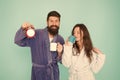 Couple in bathrobes with mugs. Man with beard and sleepy woman enjoy morning coffee or tea. Time to wake up and have Royalty Free Stock Photo