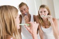 Couple in bathroom brushing teeth