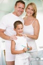Couple in bathroom with young boy brushing teeth Royalty Free Stock Photo