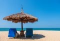 Couple beach chairs and umbrella on tropical beach with sea and blue sky background. Royalty Free Stock Photo