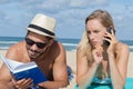 Couple on beach with mobile phones Royalty Free Stock Photo