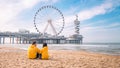 couple on the beach of Scheveningen Netherlands during Spring, Ferris Wheel The Pier at Scheveningen