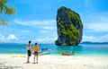 Couple on the beach, standing holding hands looking at the beautiful sea view at Poda Island - Krabi Thailand