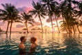 Couple at beach vacation holidays resort relaxing in swimming pool with scenic tropical landscape at sunset, romantic summer Royalty Free Stock Photo