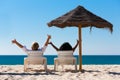 Couple on beach vacation with sunshade Royalty Free Stock Photo