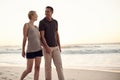 Couple, beach and walking evening on holiday for marriage connection in paradise or honeymoon, sunshine or together. Man Royalty Free Stock Photo