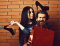 Bearded man and pretty sexy woman with shopping bag, shoes Royalty Free Stock Photo