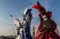 Couple with beautiful costume and venetian mask during venice carnival with campanile in the background Royalty Free Stock Photo