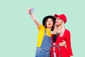 Couple of beautiful stilysh hipster best friends in fashionable clothes hugging with love, posing for camera and making selfie,
