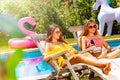 Couple of beautiful teen girls sit deck chairs