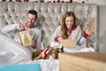 Couple In Bed At Home With Dog Dressed In Santa Costume Opening Gifts On Christmas Day Royalty Free Stock Photo