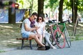 Couple With Bicycle Sitting On Beanch