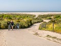 Couple with bicycles on steep hill of Duinhoevepad in dunes near Renesse on Schouwen-Duiveland, Zeeland, Netherlands