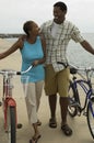 Couple With Bicycles Walking On Beach Royalty Free Stock Photo