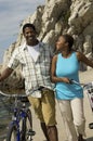 Couple With Bicycles Walking On Beach Royalty Free Stock Photo