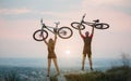 Couple bicyclist with mountain bikes on the hill at sunset Royalty Free Stock Photo