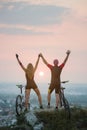 Couple bicyclist with mountain bikes on the hill at sunset Royalty Free Stock Photo