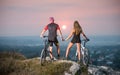 Couple bicyclist with mountain bikes on the hill at sunset Royalty Free Stock Photo